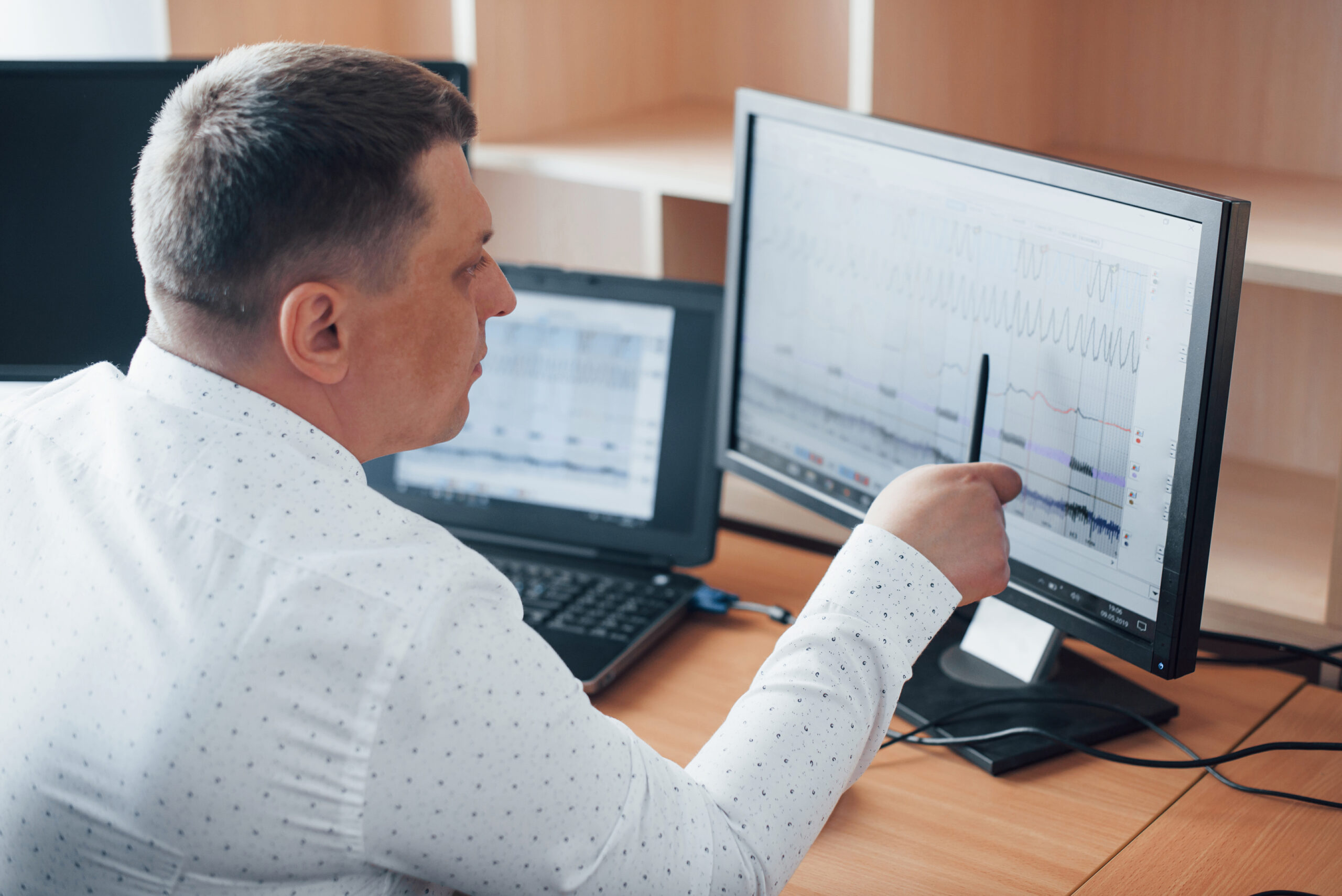Profissional analisando informações em um sistema de gestão no computador.